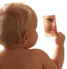 Bebê olhando-se no espelho