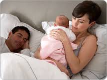 casal na cama com bebê