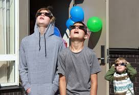 Filhos observando eclipse